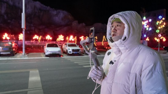 在吉林市阿什哈达雾凇观景带,雾凇播报员正在直播。新华社记者 李典 摄