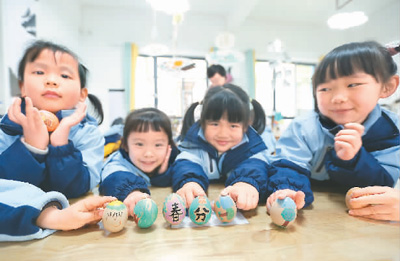 3月18日,贵州省黔南布依族苗族自治州都匀市青云湖幼儿园的小朋友们在体验立蛋民俗。肖 伟摄(人民视觉)