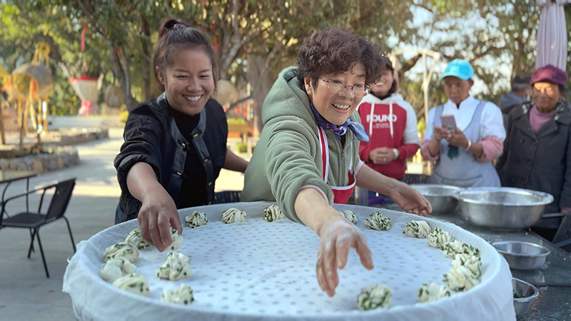 【2】旅居者赵发英（图左二）教曼海村村民做花卷。陶思源-摄
