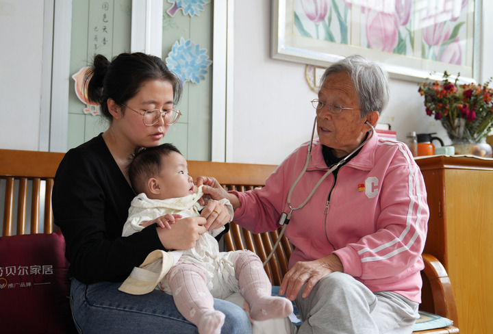 2024年9月10日,在陕西省榆林市佳县,路生梅在自己的住所为患儿听诊。新华社记者 吴鸿波 摄